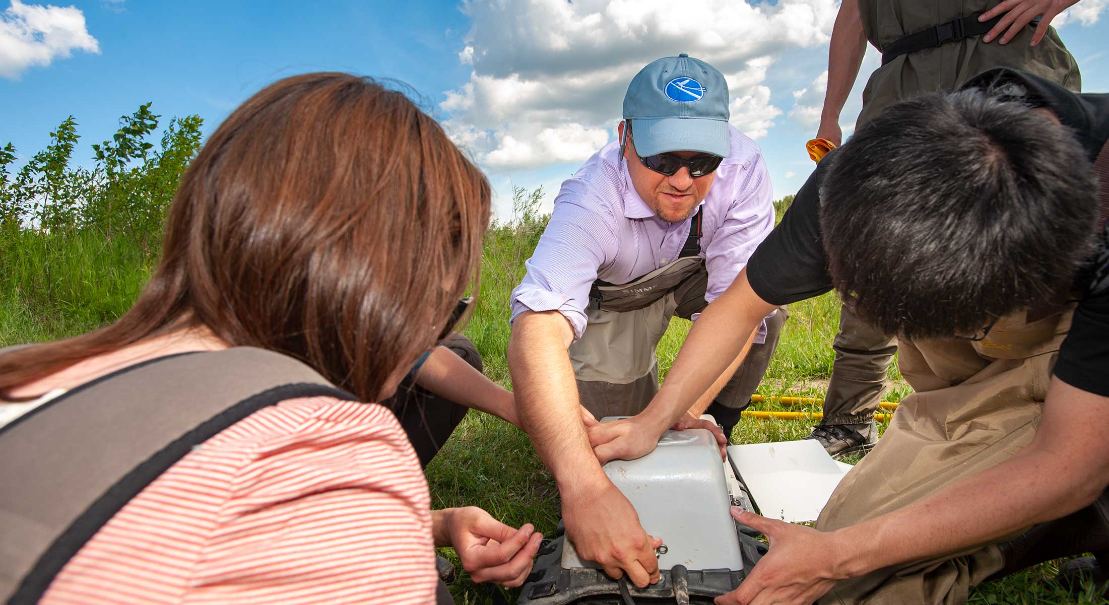 A faculty member with students in a field setting