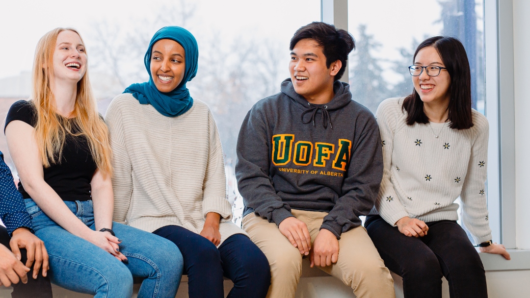 Four people sitting on a window seal