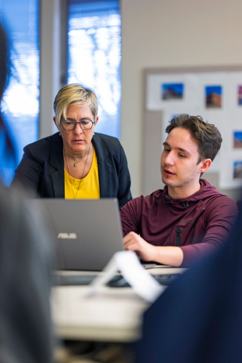 Urban planning researcher Kyle Whitfield works with a student in the classroom.